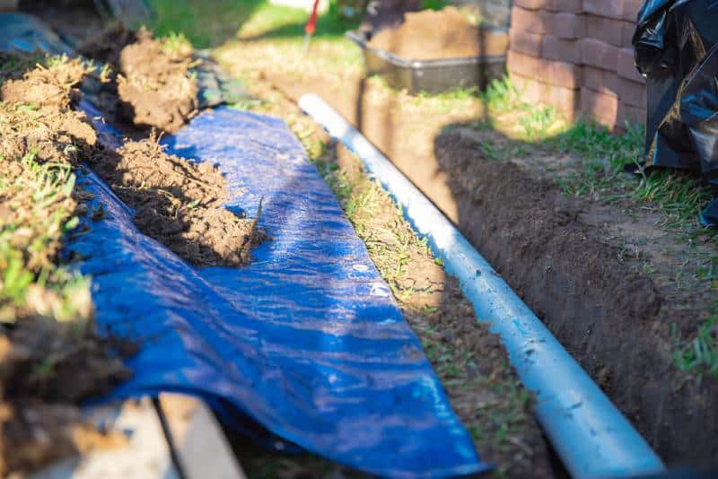 A trench is dug for a residential sewer line replacement.