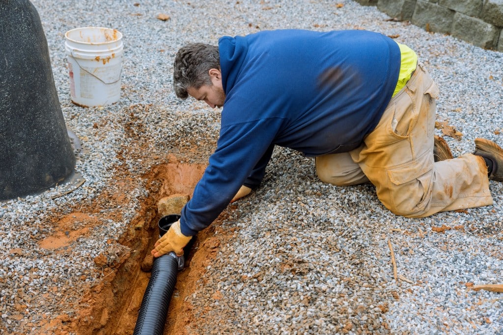 A plumbing technician performs a sewer line replacement.